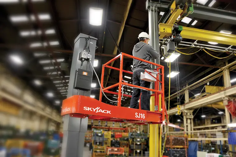 Travailleur sur un appareil de levage électrique SKYJACK orange pour une personne