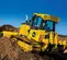 Bouteur 110 ch John Deere jaune déplaçant de la terre sur une pente avec un travailleur dans la cabine