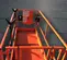 Top view of an orange vertical mast lift bucket platform with safety rails around the sides.