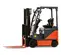 Side view of a black and orange electric warehouse forklift with black lifting mast and orange forks with an open cabin.