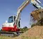 White, red and gray TAKEUCHI 10,000-12,000 lb. Mini Excavator