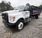 Front view of the right side of a white Ford truck with a flatbed.