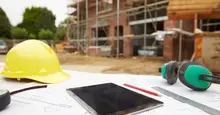 tablet and hard hat on construction site outside