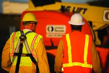 two men in ppe near boom lift
