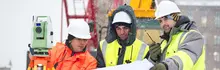 Travailleurs portant des gilets de sécurité et des casques de sécurité sur un chantier de construction en hiver