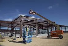 Travailleur à l’intérieur d’un appareil de levage sur le chantier
