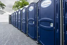 A row of blue porta potties at an event